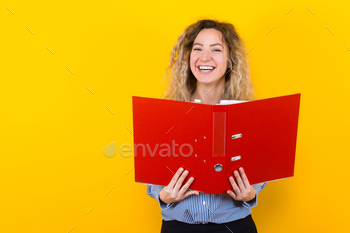 ped shirt isolated on orange background holding open big folder with files graduate or course work report presentation concept.