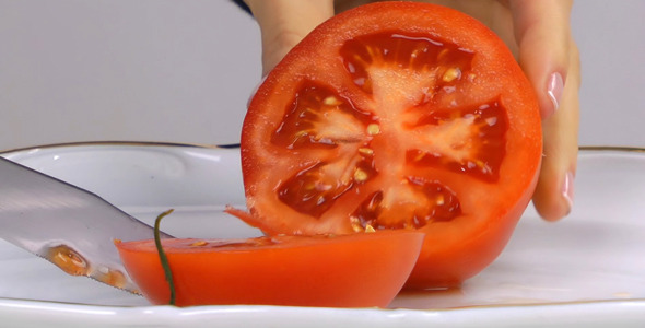 Female Hand Cutting Tomato