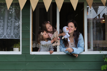 inside a rustic home, a mother and her twin girls find reason to giggle and jest, proving that