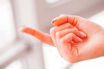 Vision Contact Lenses. Woman holds finger on a contact lens, closeup