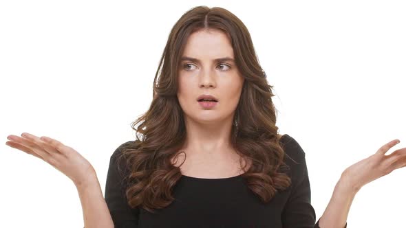 Confused Beautiful Caucasian Female with Long Brunette Hair Standing at Loss on White Background in