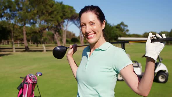 Golfer carrying golf club over shoulder while standing on the golf course