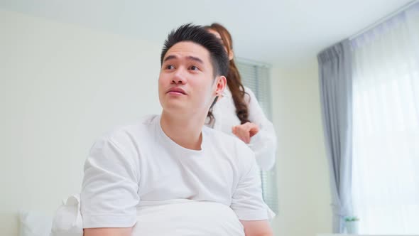 Portrait of Asian new marriage couple lying on bed and look each other.