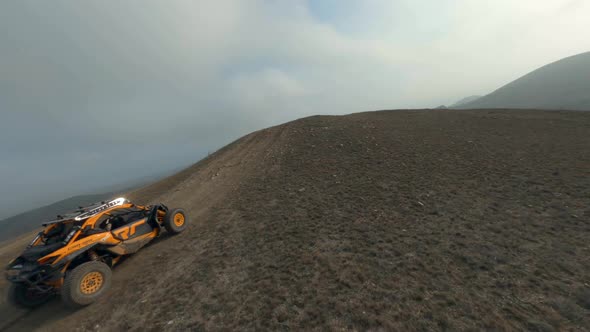 Shooting From Sports Fpv Drone Extreme Orange Buggy Car Racing Speed Riding on Hilly Terrain