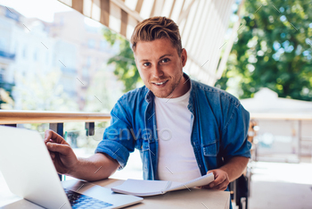 handsome man student learning course and making researches using technologies on terrace