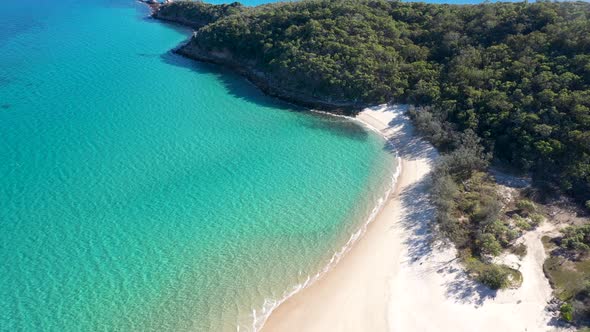 Stunning turquoise tropical water, empty white sand beach and bushland aerial over Great Keppel Isla