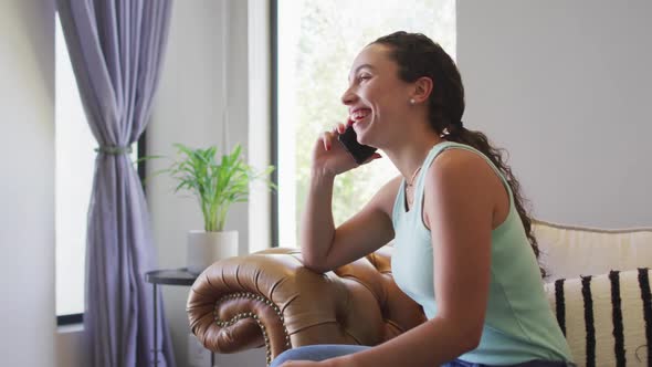 Happy caucasian woman spending time at home and using smartphone