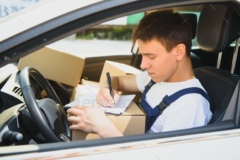 Young Delivery Man Checking List On Clipboard In car