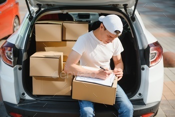 Young Delivery Man Checking List On Clipboard In car