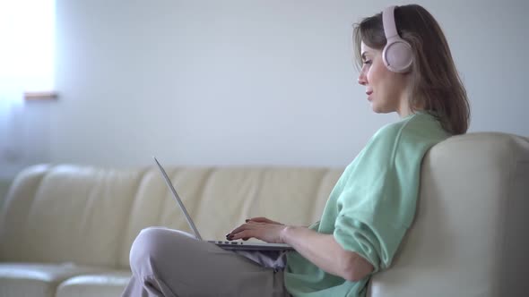 Adult Woman Working at Home While Sitting on the Couch