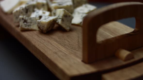 Female Hand Putting Sliced Red Onion on a Wooden Tray Table Near Other Ingredients for Tuna Pizza