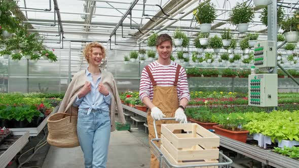 Smile Woman Housewife Buys a Plant in the Nursery and Talks to the Gardener