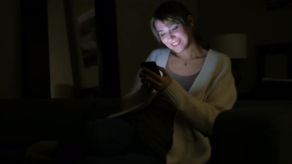 Woman Reacting to Success while Using Phone at Night