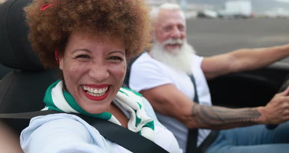 Trendy elderly couple having fun doing a road trip during vacation