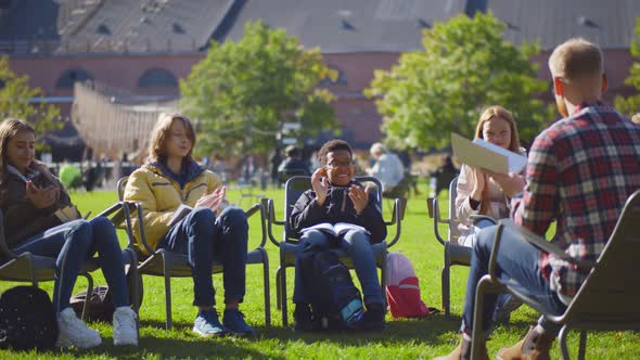 Group of Diverse Schoolchildren with Teacher Applauding Enjoying Outdoors Lesson