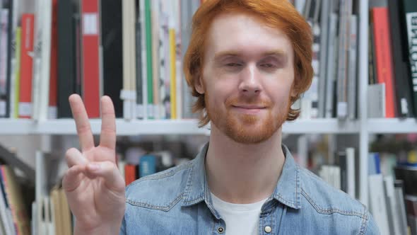 Victory Sign by Beard Man in Office