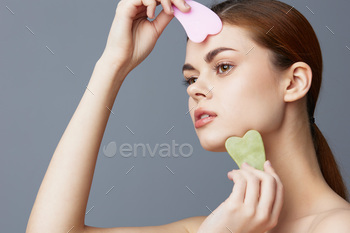 beautiful woman facial scraper skin care posing isolated background