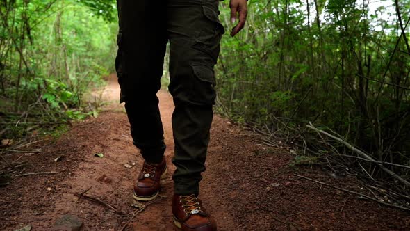 slow-motion of hiking man with trekking boots walking in the natural forest