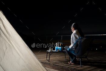 Woman go camping and cooking for dinner at night with her tent