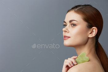 beautiful woman facial scraper skin care posing isolated background