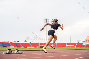 Asian young sportswoman sprint on a running track outdoors on stadium.