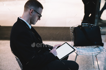 Illustrator in suit sitting and working on tablet