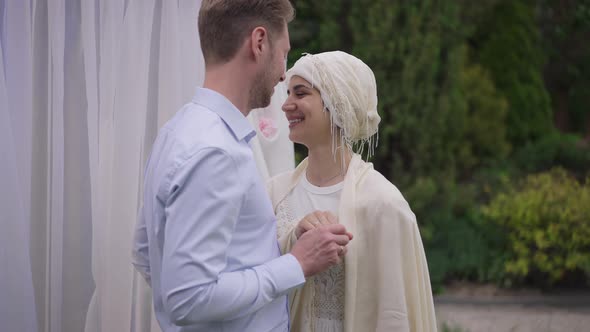 Portrait of Smiling Happy Middle Eastern Bride Holding Hands with Caucasian Groom