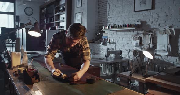 Male Artisan Using Leather Cutter