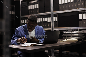 ch, working overtime at bureaucracy record in storage room. Businessman analyzing administrative files, searching for accountancy report