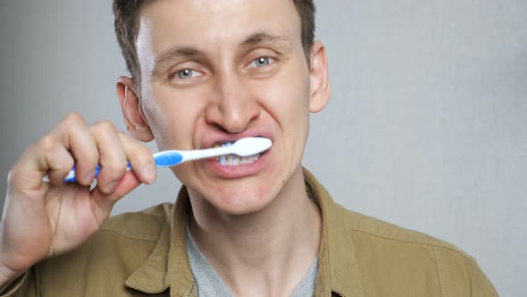 Close Up Head Shot Young Man Brushing Teeth in Bathroom