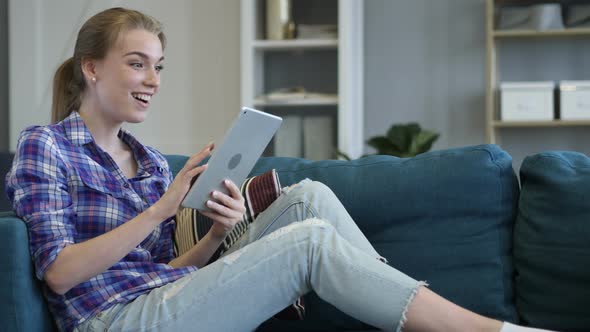 Excited Woman Celebrating Success while Using Tablet