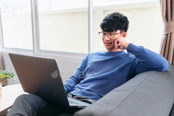 Asian man in casual clothes, using laptop to working about busin