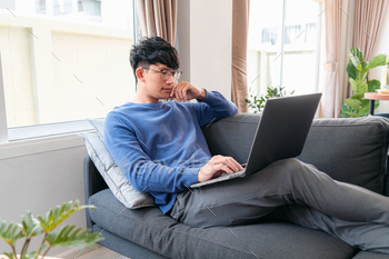 Asian man in casual clothes, using laptop to working about busin