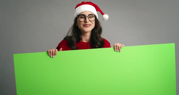 Woman pointing on Christmas banner with copy space