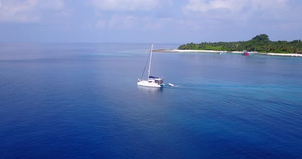 Beautiful above travel shot of a sandy white paradise beach and blue sea background in vibrant