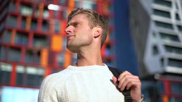 Slowmotion Lowangle Mature Attractive Blond Man Holding Backpack Turning Around Searching Friend
