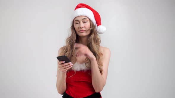 Woman Christmas Santa Hat White Studio Background with Smartphone in Hand