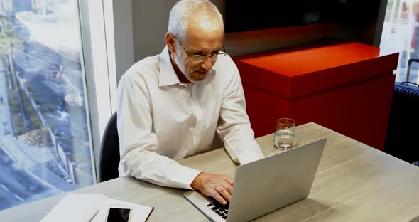 Businessman using laptop in hotel room 