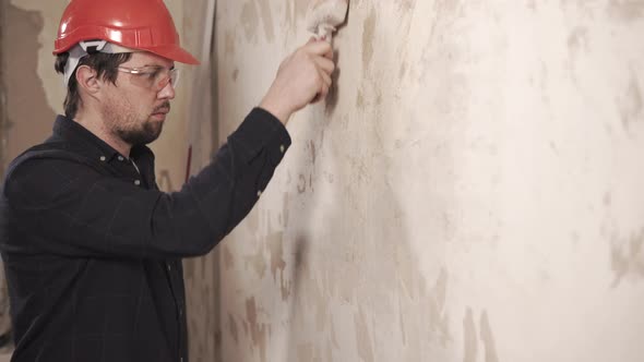 Workman Is Covering Wall in Living Flat By Building Mortar, Using Brush