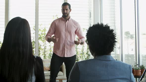 Handsome Young Worker Speaking To Colleagues