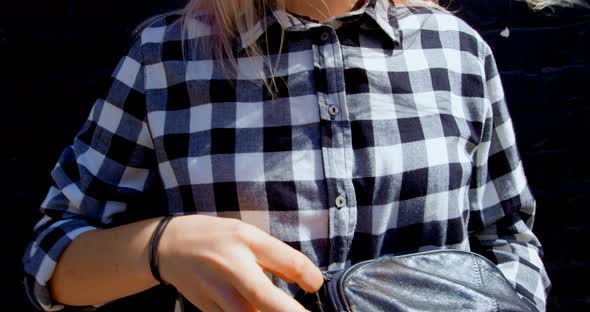 Young woman closing waist bag on sunny day 4k