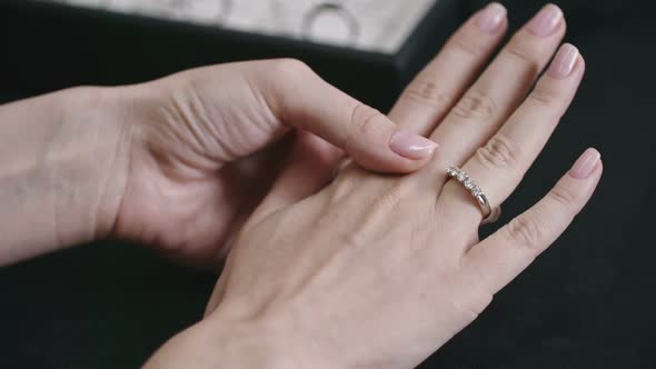 Woman Putting Silver Diamond Ring on Her Finger