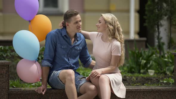 People in Love Sitting on Bench, Guy Holding Balloons, Carefree Romantic Mood
