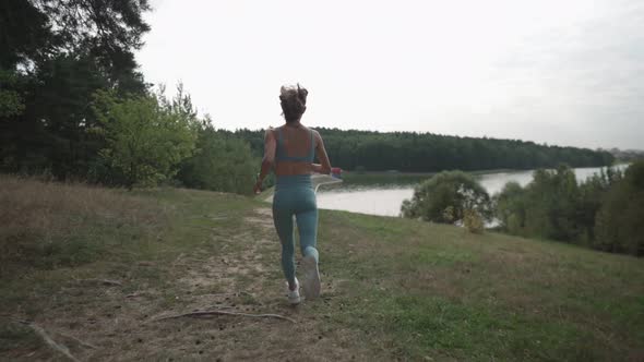 Side View of a Woman Running Uphill in a Forest