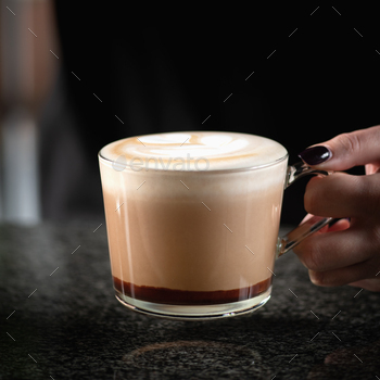 Barista's Hand Holds Mocha Coffee in a Glass Cup