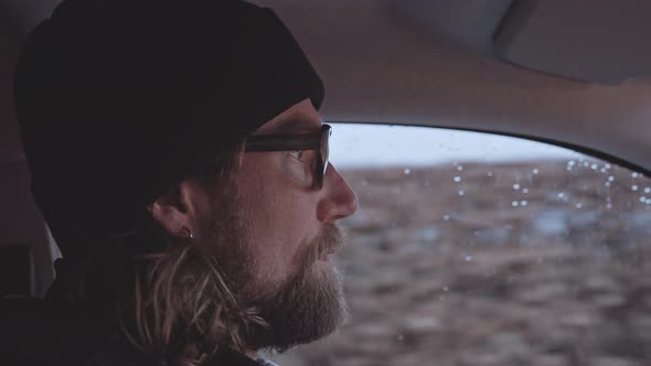 Bearded Man With Glasses Driving Along