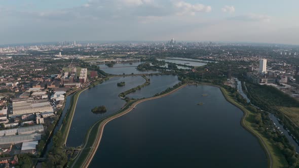 Dolly forward drone shot over north London water reservoirs Walthamstow towards city skyline