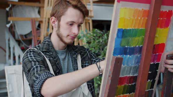 Portrait of Serious Guy Painting in Art Studio Concentrated on Creative Activity