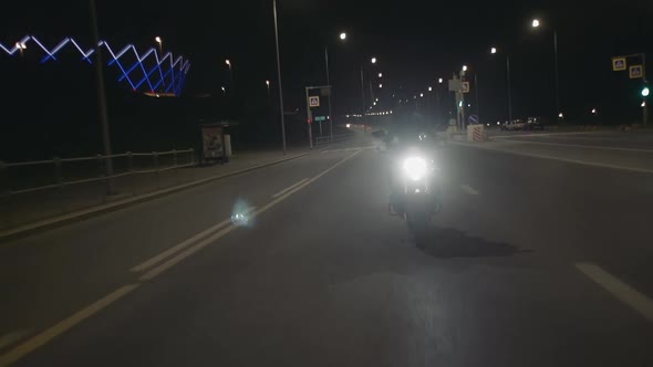 Young Woman Biker Rides a Motorbike in Helmet on the Road Front View