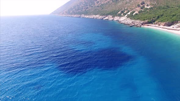 Blue water at beach next to mountains